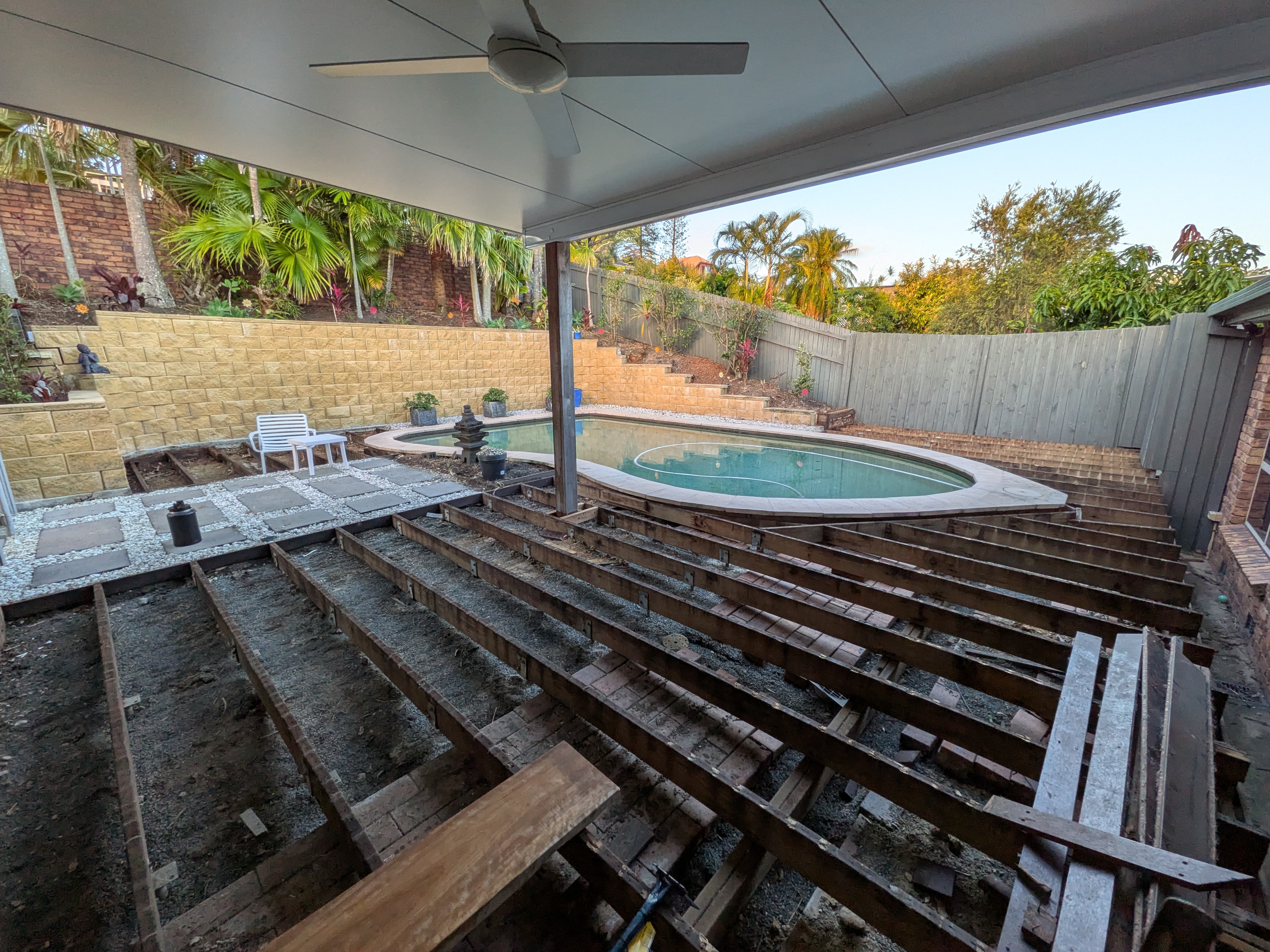 Deck demolition prep work showing exposed joists by pool