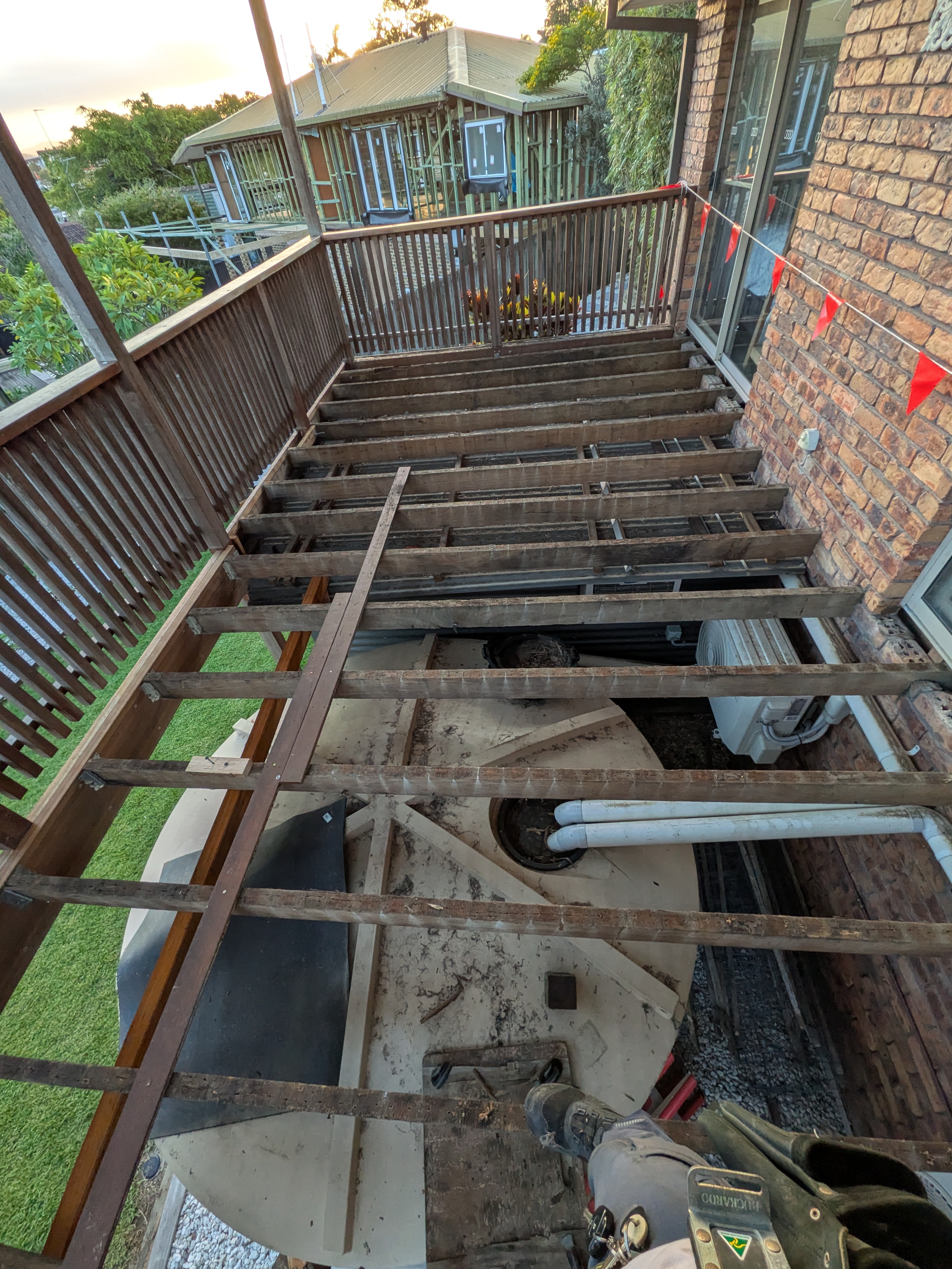 Elevated deck demolition in progress, boards removed